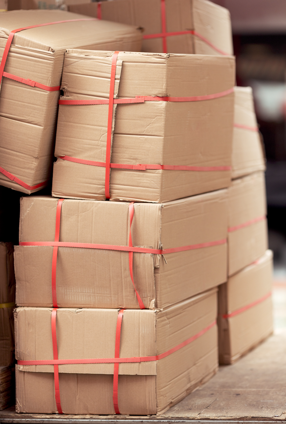 Boxes stacked three high and two wide with red plastic straps securing them